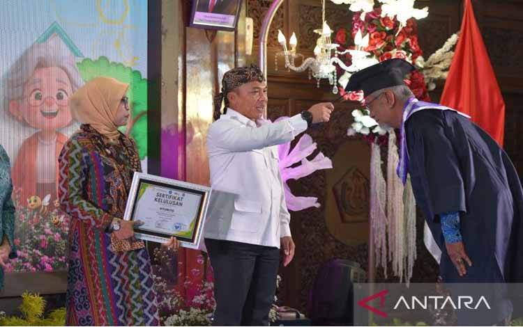 Mendukbangga/Kepala BKKBN Wihaji (berkemeja putih) bersama sang istri di sebelah kirinya saat mewisuda salah satu siswa Sekolah Lansia di Kabupaten Lamongan, Jawa Timur, pada Kamis (4/12/2025). ANTARA/HO-Kemendukbangga/BKKBN.