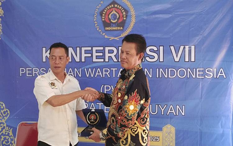 Ketua PWI Kalteng M Zainal menyerahkan plakat kepada Bupati Seruyan Ahmad Selanorwanda saat membuka Konferensi VII PWI Seruyan. (Foto : Fahrul)