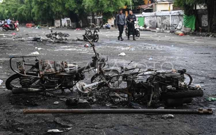 Warga melintas di samping sepeda motor yang terbakar pascakericuhan di kawasan Kalibata, Jakarta, Jumat (12/12/2025). ANTARA FOTO/Sulthony Hasanuddin/nym.