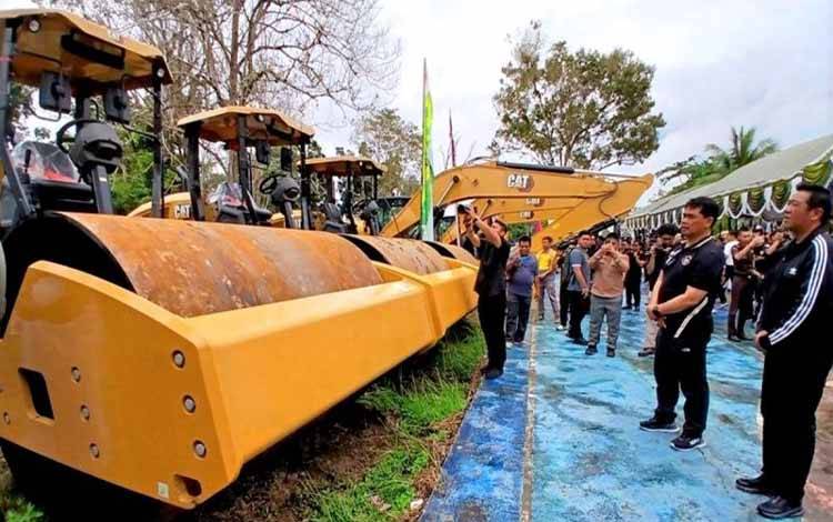 Bupati Barito Utara Shalahuddin (kedua kiri) didampingi Wakil Bupati Felix Sonadie Y Tingan (kanan) menerima 12 unit alat berat Cartepilar di halaman Dinas PUPR setempat, Muara Teweh, Jumat (12/12/2025). ANTARA/Dokumen Pribadi