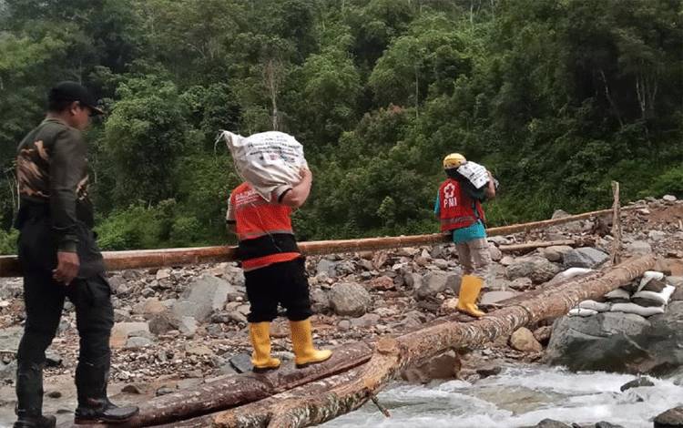 Relawan Kota Tangerang dari Baznas dan PMI membawa logistik bantuan menyusuri dan menyebrangi sungai menuju ke pemukiman warga terdampak banjir dan longsor di Sumatera Barat. ANTARA/HO-Baznas Kota Tangerang.