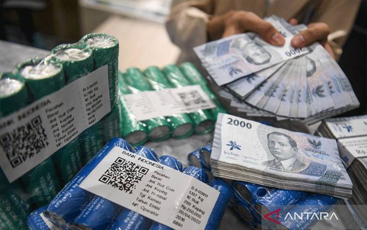 Petugas menunjukkan uang rupiah di Kantor Cabang BNI Pasar Baru, Jakarta, Senin (27/10/2025). Bank Indonesia memutuskan untuk mempertahankan BI-Rate sebesar 4,75 persen, suku bunga Deposit Facility sebesar 3,75 persen dan suku bunga Lending Facility sebesar 5,50 persen sebagai upaya mempertahankan stabilitas nilai tukar rupiah yang sesuai dengan fundamental di tengah ketidakpastian global yang masih tinggi serta sinergi untuk turut memperkuat pertumbuhan ekonomi. ANTARA FOTO/Muhammad Adimaja/nym