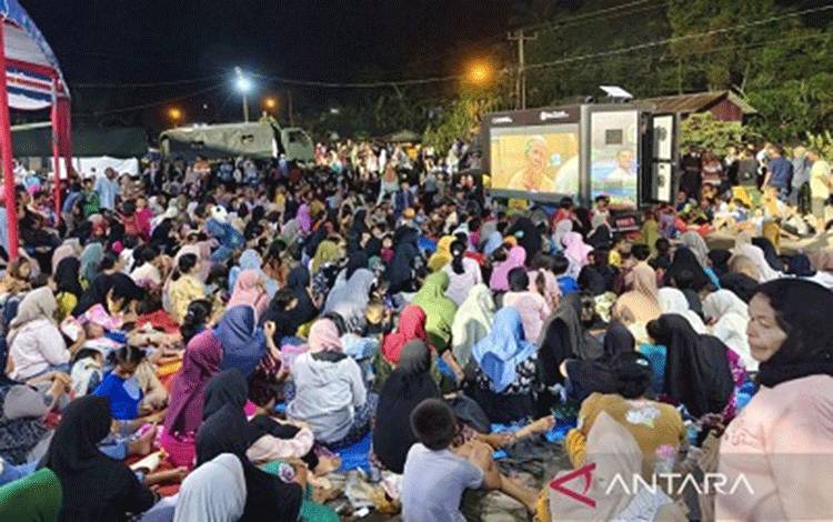 Warga menyaksikan film yang diputar di posko pengungsian Batu Hula, Batang Toru, Tapanuli Selatan, Sumatera Utara, Rabu (31/12/2025). (ANTARA/Fathur Rochman)