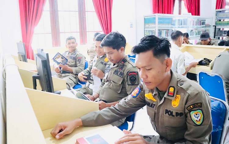 Anggota Satpol PP Seruyan saat pelaksanaan Satpol Gemar Membaca (SGM) di Perpustakaan Daerah Kabupaten Seruyan (Foto : Ist)