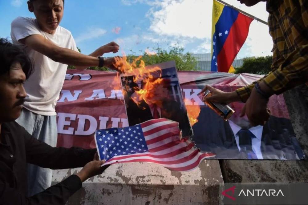 Pengunjuk rasa dari berbagai aliansi membakar bendera AS dan poster bergambar presiden AS Donald Trump saat menggelar aksi solidaritas untuk Venezuela di depan Kedutaan Besar Amerika Serikat, Jakarta, Selasa (6/1/2026). ANTARA FOTO/Indrianto Eko Suwarso/YU
