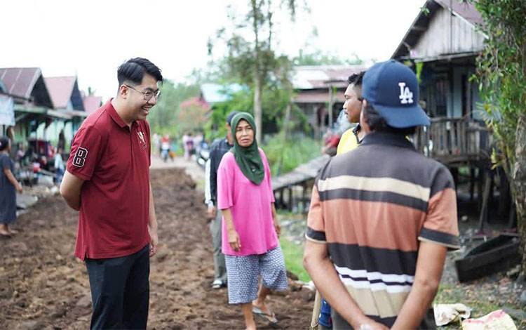 Aktivitas anggota DPRD Palangka Raya Erlan Audri (Baju merah) saat bersama warga. (Foto: MARINI)