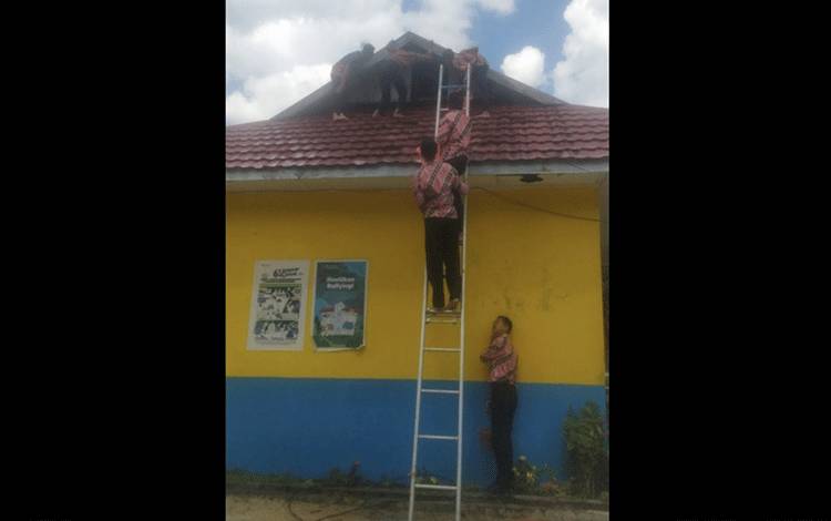 Tampak pelajar SMKN 2 Pangkalan Bun melakukan upaya pemadaman di bagian atap ruang OSIS.