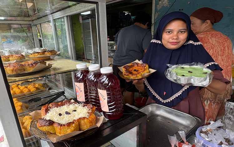 Pedagang kue saat menunjukkan bingka kentang. (FOTO : IST)?