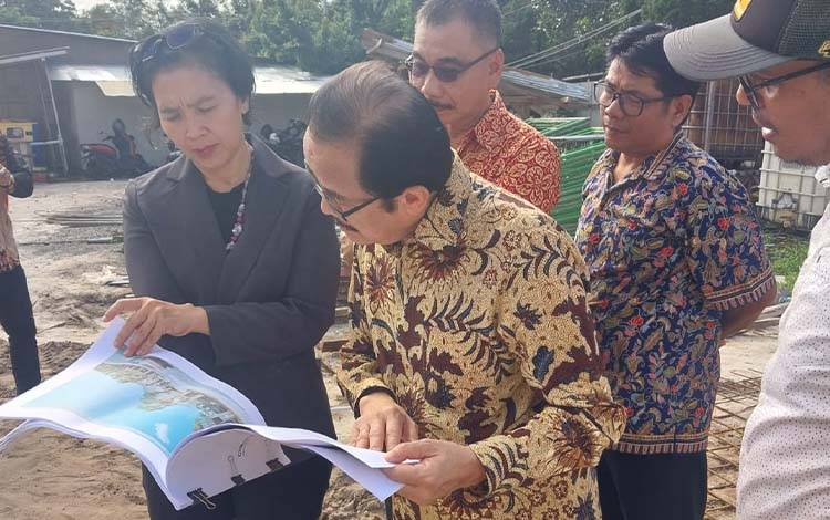 Anggota DPD RI Dapil Kalimantan Tengah, Agustin Teras Narang melihat blueprint pembangunan gereja Maranatha Palangka Raya. (FOTO: Istimewa)