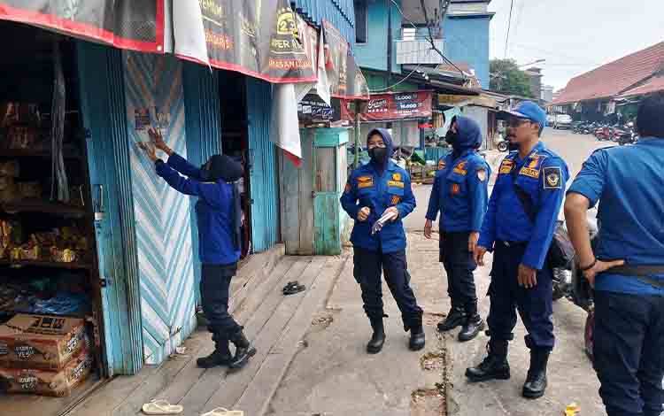 Petugas Damkar Seruyan saat memasang Pamflet dan memberikan sosialisasi secara langsung kepada warga. (Foto: Ist)