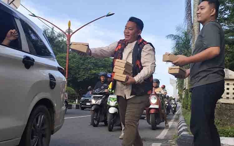 Ketua MPC Pemuda Pancasila Kota Palangka Raya Bush Valentino Lambung saat membagikan takjil di Jalan Yos Sudarso Palangka Raya. (FOTO: PATHUR)