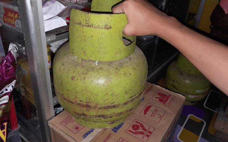 Warga menunjukkan tabung gas LPG 3 Kg. (Foto:MARINI)