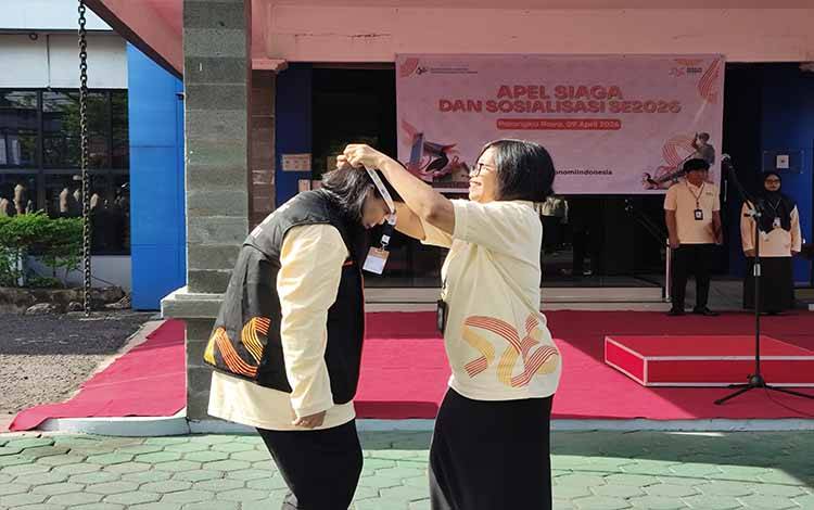 Pengalungan kartu pengenal kepada Ketua Panitia SE2026 oleh Kepala BPS Kalteng, Agnes Widiastuti pada Apel Siaga, Kamis, 9 April 2026 sebagai tanda kesiapan pelaksanaan SE2026 di Kalimantan Tengah.(FOTO: TESTI PRISCILLA)
