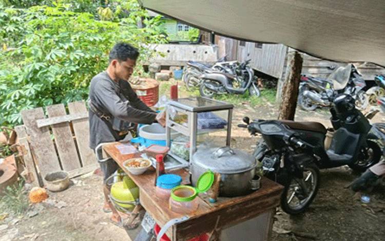Pedagang pentol keliling Kecamatan Banama Tingang, Kabupaten Pulang Pisau, Dodo saat menyajikan menu bakso kepada pembeli. (Foto:MARINI)