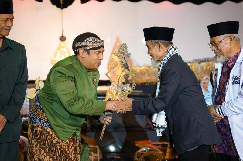 Pimpinan PMDG KH Hasan Abdullah Sahal menyerahkan wayang kepada dalang Ki Bayu Aji sebagai tanda dimulainya pagelaran wayang kulit dalam rangka 100 Tahun Pondok Modern Darussalam Gontor di Lapangan Hijau PMDG, Desa Gontor, Kecamatan Mlarak, Kabupaten Ponorogo, Jawa Timur, Sabtu (6/6/2026). Antara/HO - Humas PMD Gontor Ponorogo
