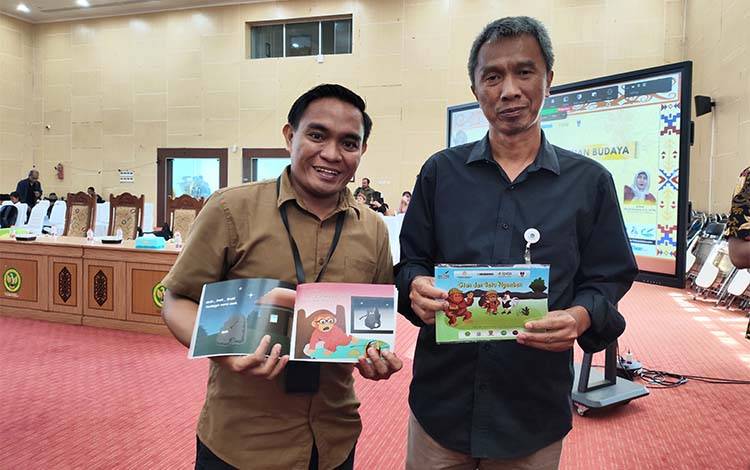 Kepala Balai Bahasa Kalteng, Sukardi Gau (kanan) saat menerima salah satu produk alihwahana yang dihasilkan dalam Festival Sastra dan Sarasehan Budaya pada Rabu, 15 Juli 2026. (FOTO: TESTI PRISCILLA)