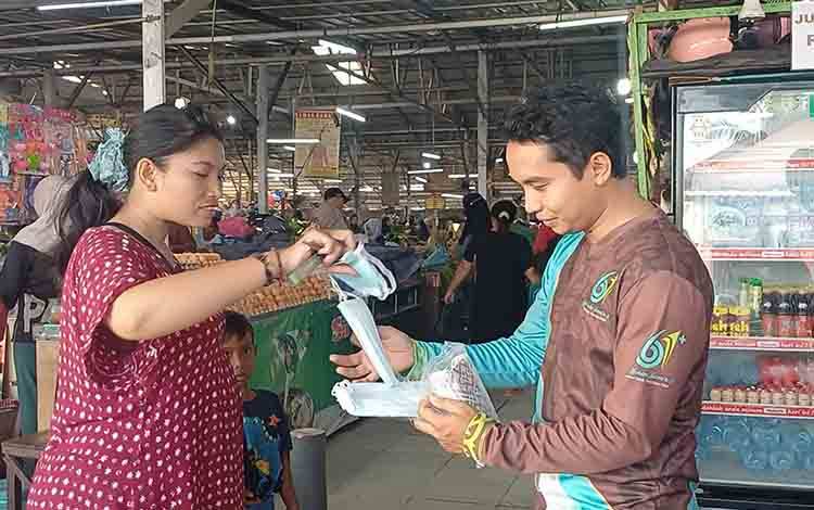 Petugas Dinas Kesehatan Kotawaringin Timur membagikan masker gratis di Pasar Al Kamal, Senin, 27 Juli 2026. (FOTO: DEWIP)
