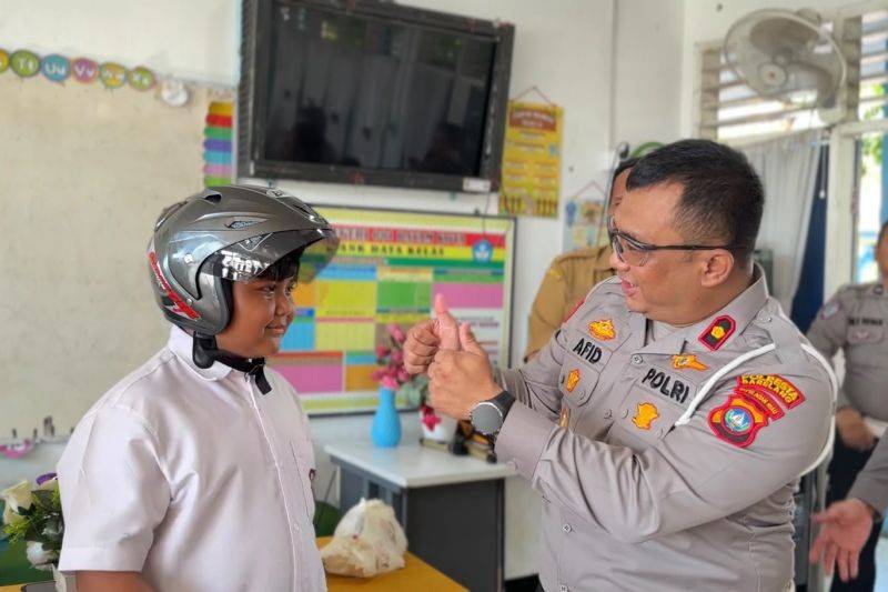 Kasatlantas Polresta Barelang Kompol Afiditya Arief Wibowo mengenakan helm kepada pelajar di kelas di Batam, Kepri. ANTARA/HO-Polresta Barelang
