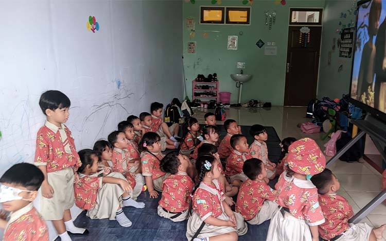 Anak-anak PAUD sedang menonton video pembelajaran di ruang kelas.? (FOTO: TESTI PRISCILLA)