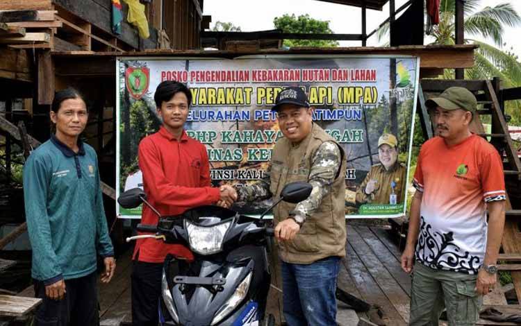 Kadishut Kalteng Agustan Saining (dua dari kanan) mewakili Gubernur Agustiar Sabran menyerahkan apresiasi berupa sepeda motor bagi Rudiansyah 'superman' pemadam karhutla (dua dari kiri) di Palangka Raya, Minggu (23/8/2026). (ANTARA/HO-Dishut Kalteng)