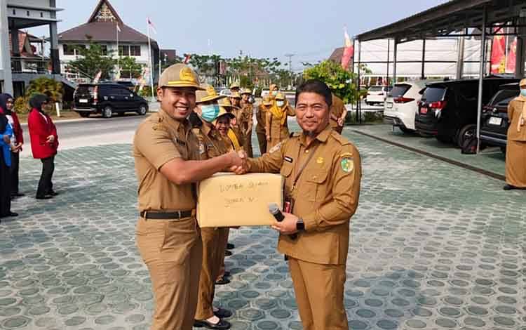 Plt Kepala BKPSDM Kota Palangka Raya Fauzi Rahman saat menyerahkan hadiah lomba HUT RI di lingkungan BKPSDM Palangka Raya. (FOTO: PATHUR)