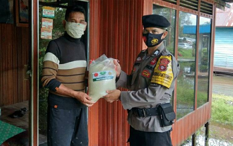 Pandemi, Bhabinkamtibmas Polsek Basarang Salurkan Bantuan Beras ke Warga