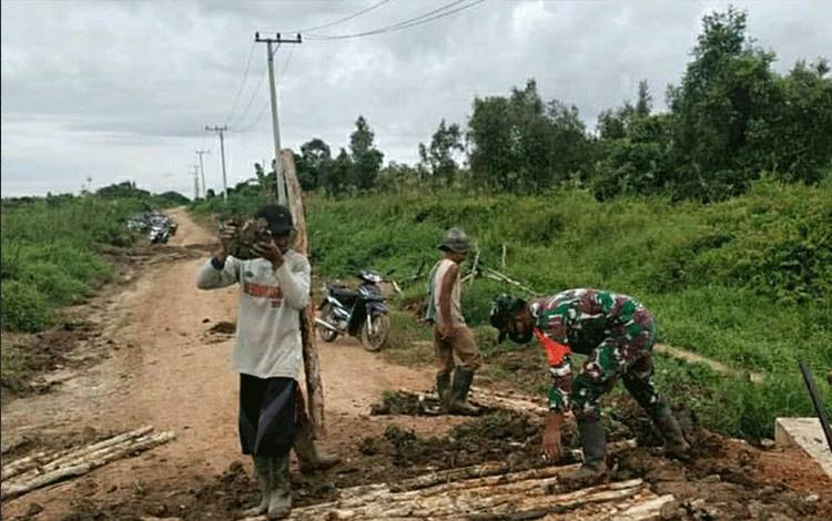 Babinsa Koramil Palingkau Ikut Gotong Royong Bersama Warga Timbun Jalan Rusak