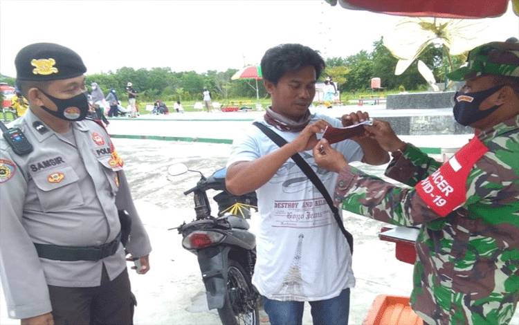 Babinsa Bersama Bhabinkamtibmas Kelurahan Sabaru Sosialisasikan Protokol Kesehatan Covid-19