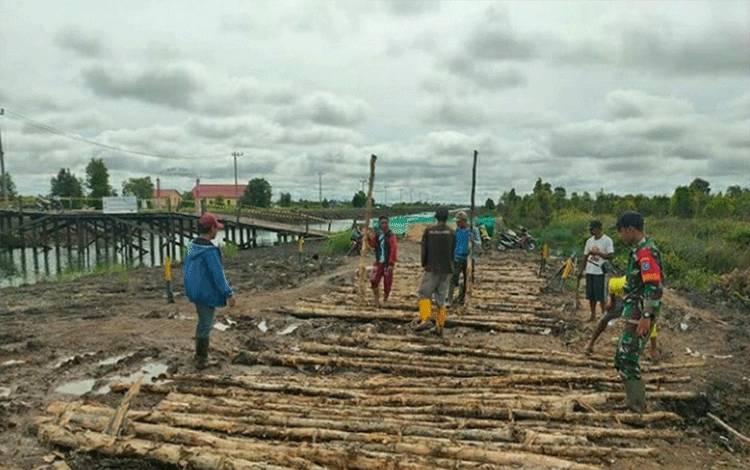 Babinsa Koramil Palingkau Ikuti Gotong Royong Bantu Penimbunan Jalan Desa