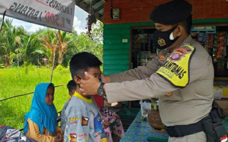 Peduli Anak-Anak di Masa Pandemi, Personel Polsek Kapuas Berikan Masker Sambil Edukasi