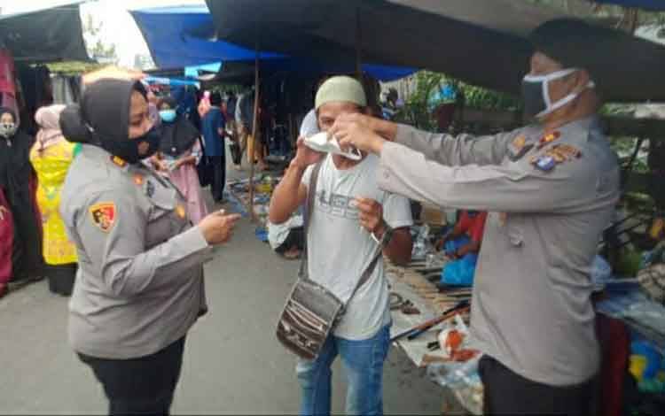 Personel Polsek Kapuas Hilir Bagikan Masker di Kawasan Pasar