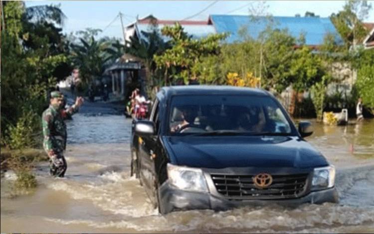 5 Desa di Gunung Mas Terendam Banjir, Babinsa Pandu Warga Sebrangi Jalan