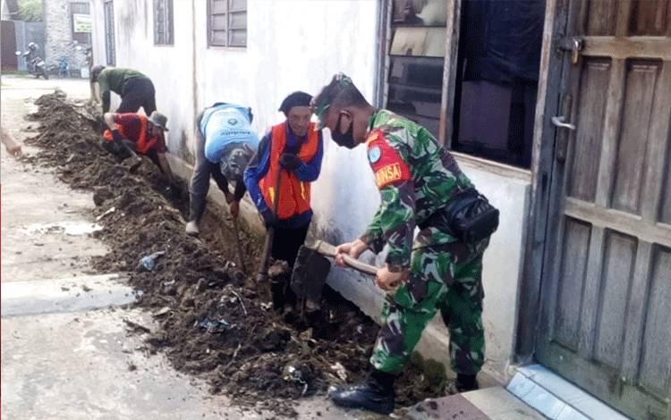 Babinsa Kelurahan Pahandut Gotong Royong Bersihkan Drainase