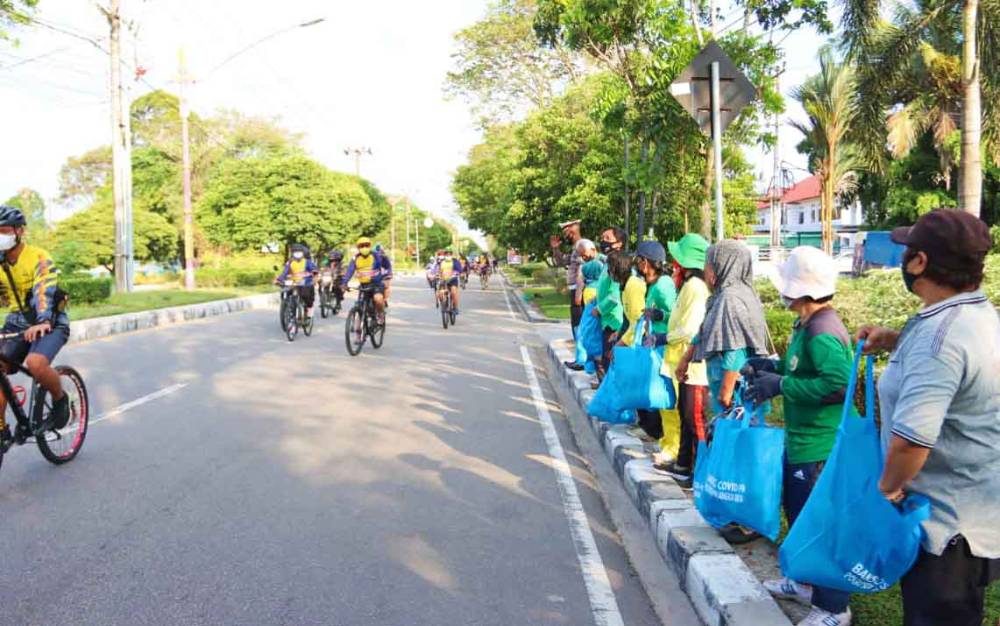 Kapolda Kalteng Bagikan Sembako dengan Bersepeda