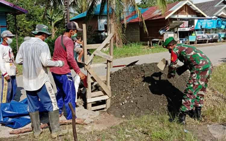 Babinsa Koramil Teweh Tengah Bahu Membahu Dengan Warga Perbaiki Jalan
