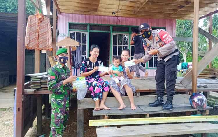 Cegah Covid-19, Babinsa Bersama Bhabinkamtibmas Lahei Bagikan Masker