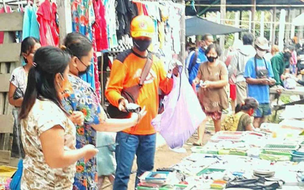 Masih Zona Merah, BPBD Damkar Barito Timur Bagikan Masker Kain di Pasar Dayu