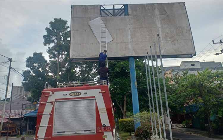 Berpotensi Jatuh, Personel Damkar Kobar Turunkan Bagian Seng Reklame Depan SMPN 1 Arsel