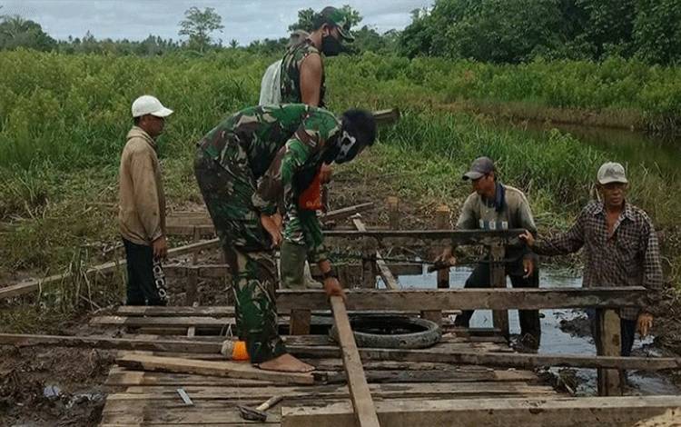 Warga Bersama Anggota Koramil Gotong Royong Perbaiki Jembatan di Saka Batur