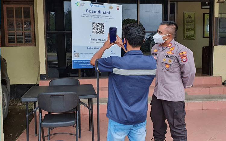 Kapolsek Pasang Banner Barcode Aplikasi PeduliLindungi di Pintu Masuk Mapolsek Kapuas Timur