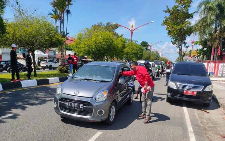 Ketua DPRD Palangka Raya Bagikan Bendera Merah Putih di Jalan