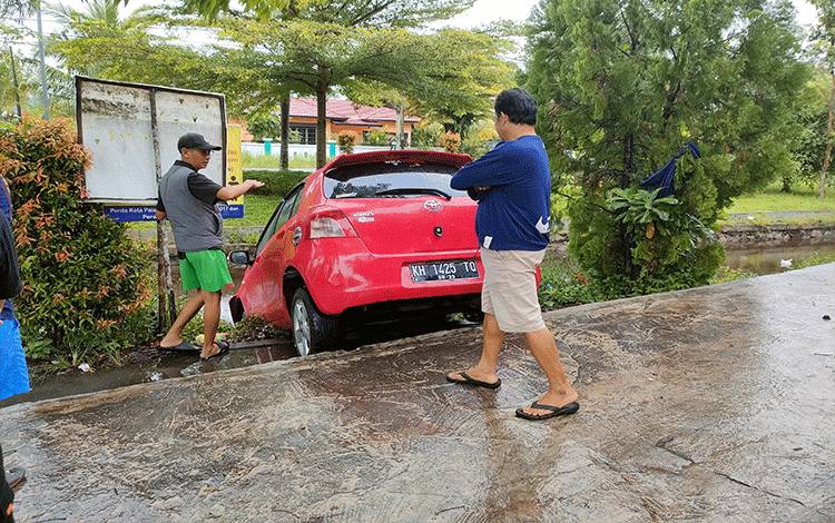 Petugas Kesulitan Evakuasi Mobil Masuk Parit di Palangka Raya