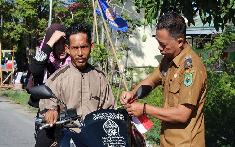 Pemdes Sei Asem Bersama Mahasiswa KKN Bagikan Bendera ke Pengendara