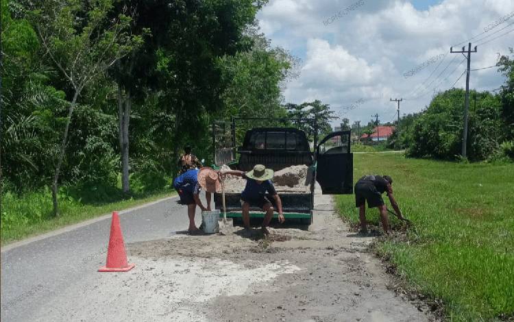 Karang Taruna Gunung Mas Bantu Tutup Lubang Jalan dengan Pasir