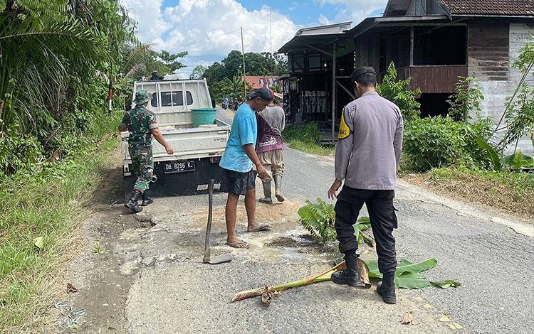 Bhabinkamtibmas dan Babinsa Swadaya Timbun Jalan Berlubang di Pematang Karau