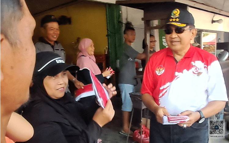 Pj Bupati Kobar Bagikan Bendera Merah Putih di CFD Bundaran Pancasila